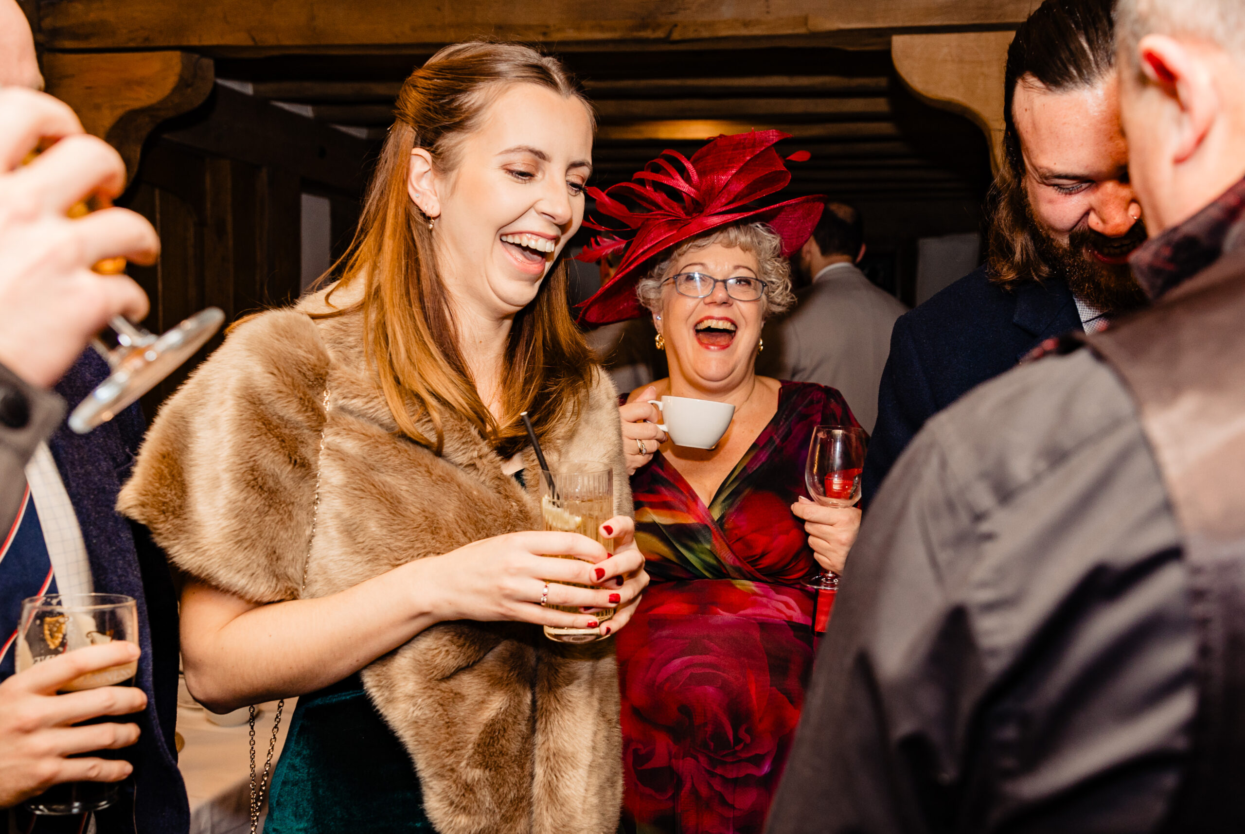 Wedding guests laughing during David Hitchcott's close-up magic at Cain Manor